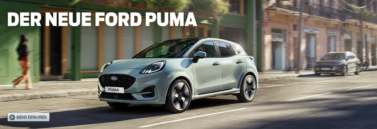 Der neue Ford Puma, ein SUV, fährt auf einer sonnigen Straße mit bunten Gebäuden im Hintergrund.