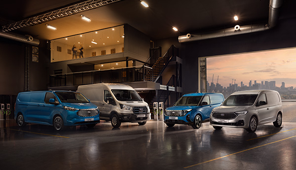 Eine Reihe von Nutzfahrzeugen in einem modernen Ausstellungsraum mit Stadtansicht im Hintergrund.