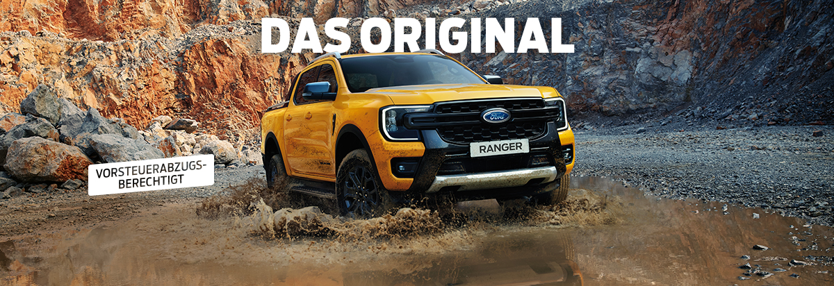 Ford Ranger in leuchtendem Gelb fährt durch schlammiges Terrain, mit felsiger Landschaft im Hintergrund.