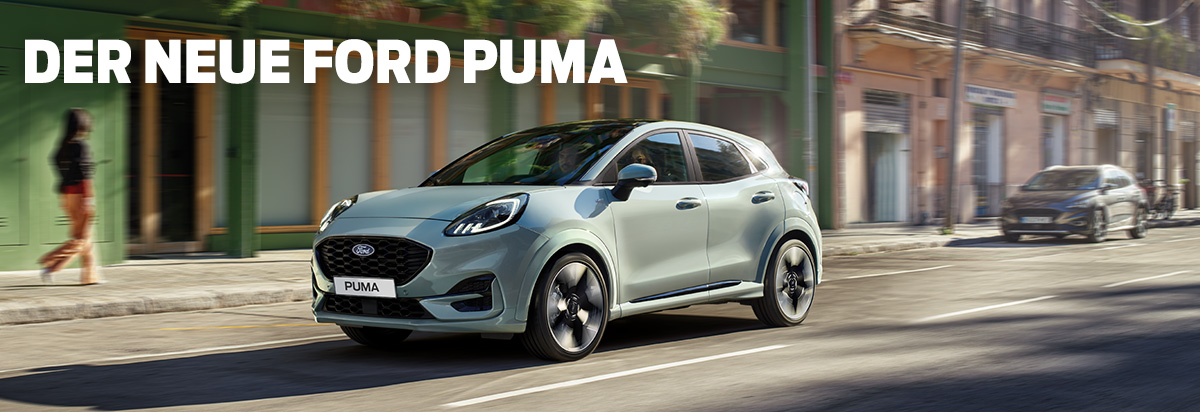 Der neue Ford Puma fährt auf einer Straße mit bunten Gebäuden im Hintergrund.