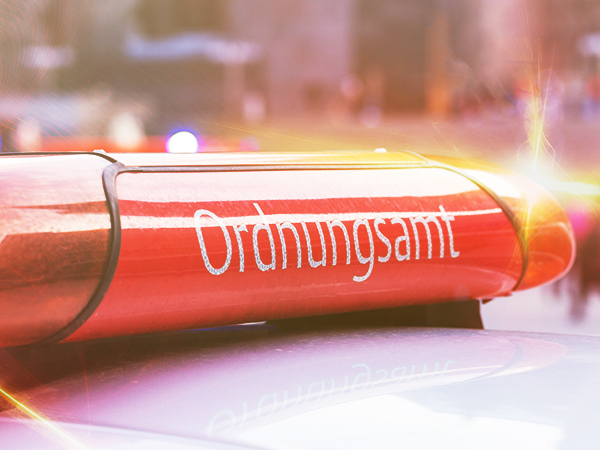 Ein rotes Blinklicht mit der Aufschrift 'Ordnungsamt' auf einem Fahrzeug bei Tageslicht.