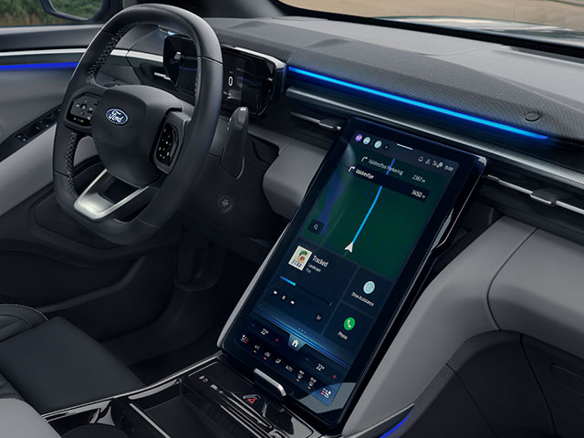 Innenansicht eines modernen Ford-Autos mit einem digitalen Armaturenbrett und großem Touchscreen.