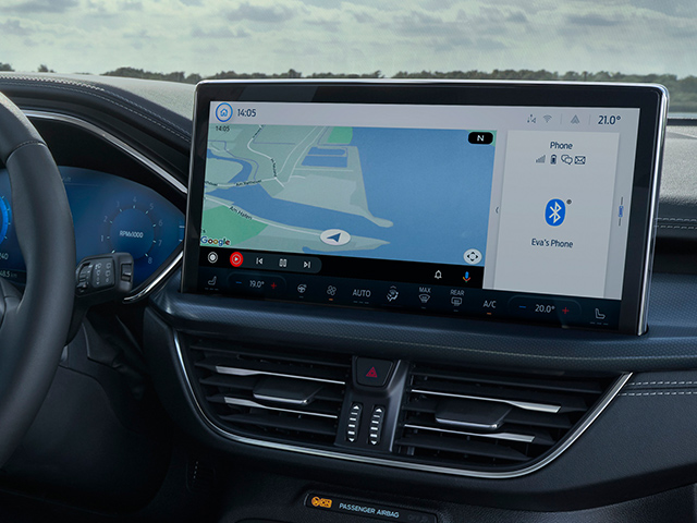 Moderne Auto-Innenansicht mit großem Navigationsdisplay und Steuerknopf am Lenkrad.