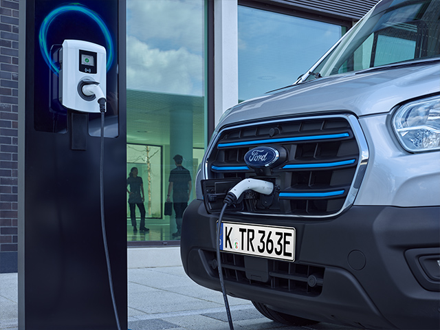 Elektroauto von Ford lädt an einer Ladestation in urbaner Umgebung.