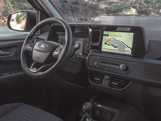 Innenansicht eines Ford-Fahrzeugs mit modernem Armaturenbrett, Lenkrad und Ledersitzen.