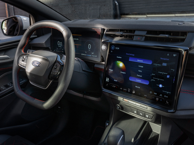 Innenansicht eines modernen Ford-Autos mit digitalem Armaturenbrett und Touchscreen-Steuerung.