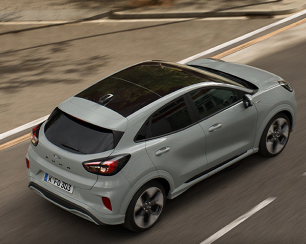 Ansicht eines grauen Autos auf einer Straße, aufgenommen aus der Vogelperspektive, mit schwarzem Dach.