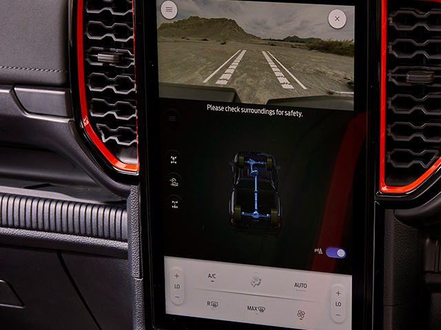 Fahrzeugdisplay mit Sicherheitswarnung und Ansicht der Umgebung in einem Auto.