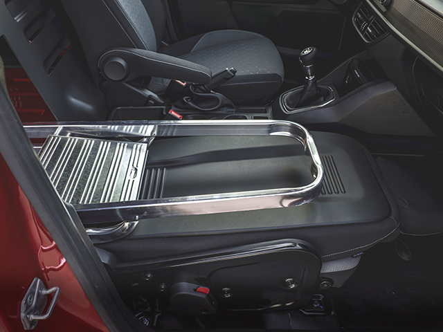 Fahrzeugansicht in der Nacht mit Navigationssystem und einem Fußgänger auf der Straße.